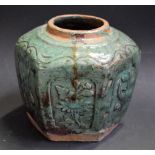 A Chinese stoneware low hexagonal jar, moulded in high relief with shaped reserves of peaches,