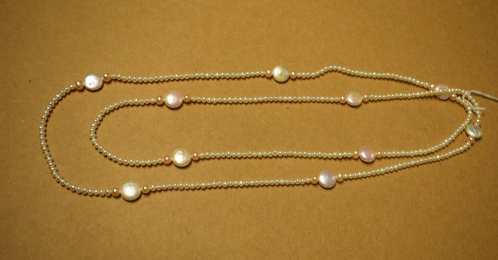 A long single strand of cultured pearl necklace, divided by ten cultured pearl discs,