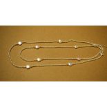 A long single strand of cultured pearl necklace, divided by ten cultured pearl discs,