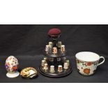 Royal Crown Derby - a thimble display stand containing fifteen patterned thimbles;