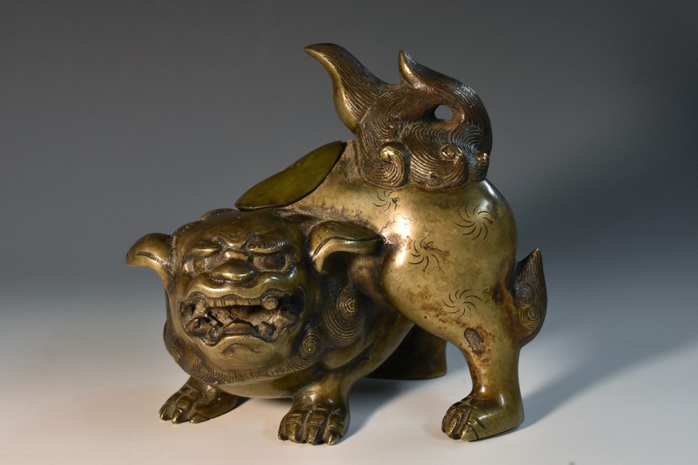 A 19th century Chinese patinated bronze censer, boldly cast as a guardian lion, its mane,