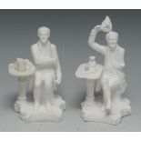 A pair of Minton biscuit porcelain figures, Chelsea Pensioners, seated by tables, 15cm high,