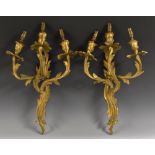 A pair of Rococo Revival ormolu three-light wall sconces, cast throughout with acanthus,