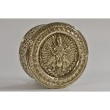 An Indian silver circular box, push-fitting cover chased with a deity astride a peacock,