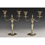 A pair of George V Adam Revival silver two-branch candelabra, adapting to singular candlesticks,