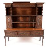 An '18th century' oak dresser, outswept cornice above an arrangement of shelves and cupboards,