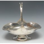 A George V silver swing handled trug-shaped cake basket, gadrooned border with flower heads,