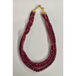 A three strand faceted ruby bead necklace,