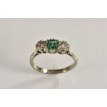 An emerald and diamond trilogy ring, central rectangular emerald approx 0.