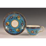 A Minton tea cup and saucer, painted with a design by Christopher dresser,