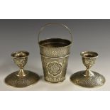 A pair of Iranian silver candlesticks, typically chased overall in the Persian taste,