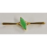 A Chinese green stone bar brooch, central set with a sing oval green stone cabochon,