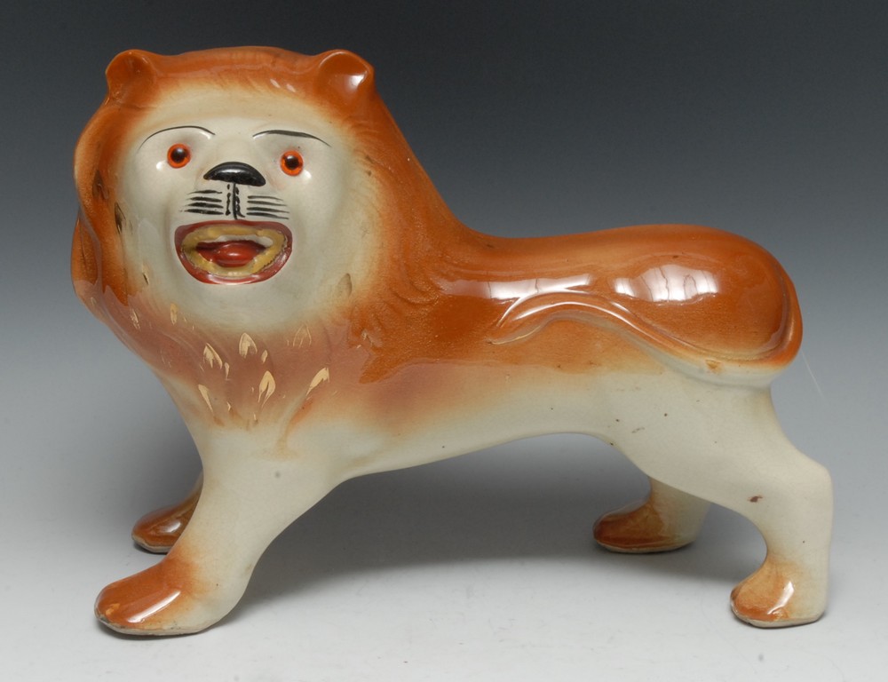 A Victorian Staffordshire lion, standing to the right, glass eyes, coloured in brown, 27cm high, c. - Image 2 of 2