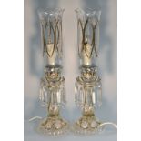 A pair of clear glass lustres, applied with white enamel flowers, picked out in gilt,