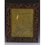 An Arts and Crafts brass rectangular panel, embossed with a longship sailing choppy seas,