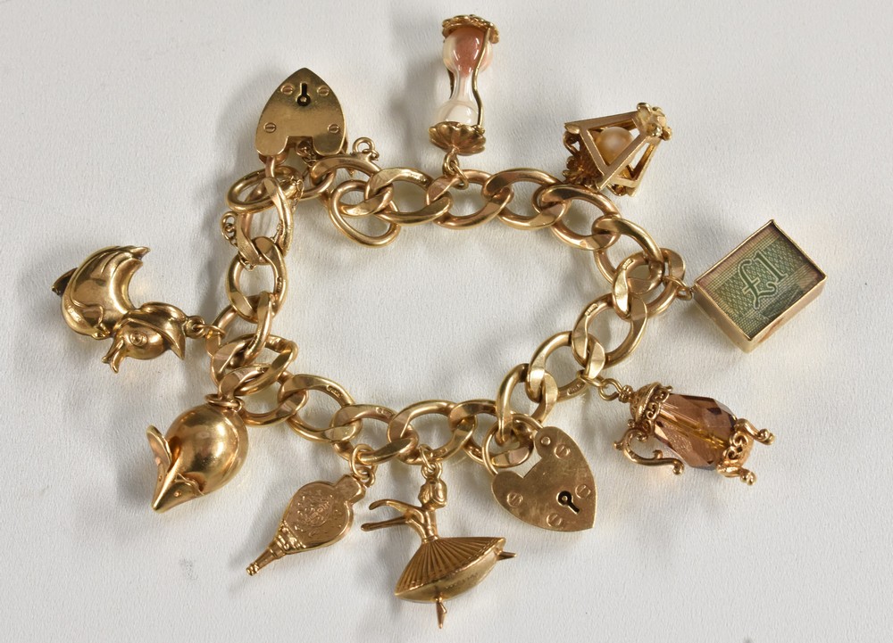 A 9ct gold curb link charm bracelet, suspending eight charms including Tankards, Lantern, duck etc,