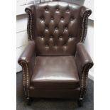 A wingback Chesterfield arm chair brown leatherette upholstery