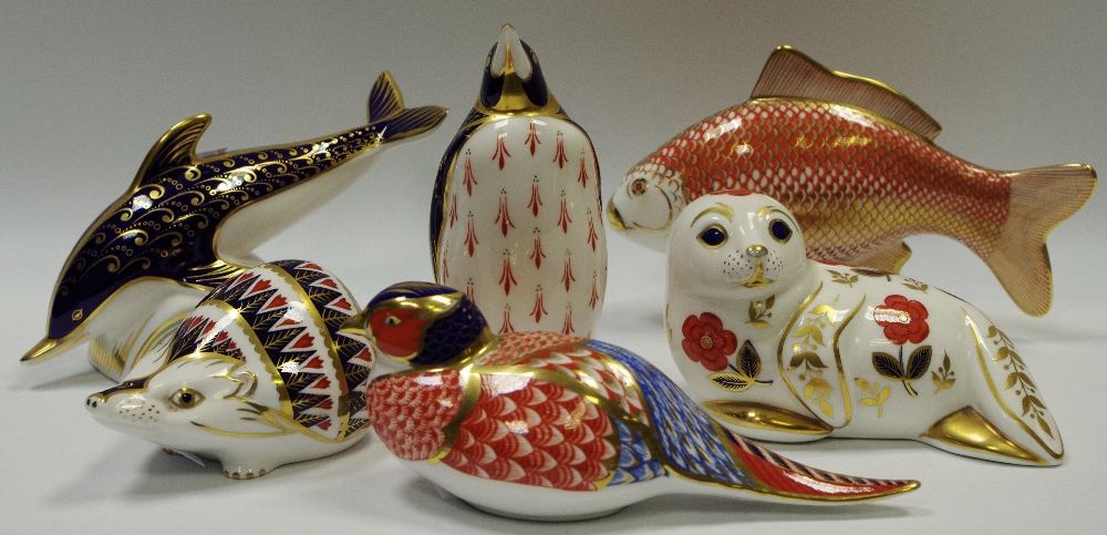 Ceramics - a Royal Crown Derby carp paperweight; a hedgehog paperweight; a dolphin paperweight;