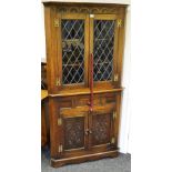 An oak priory style floor standing corner cupboard lead glazed doors to top single drawer over two