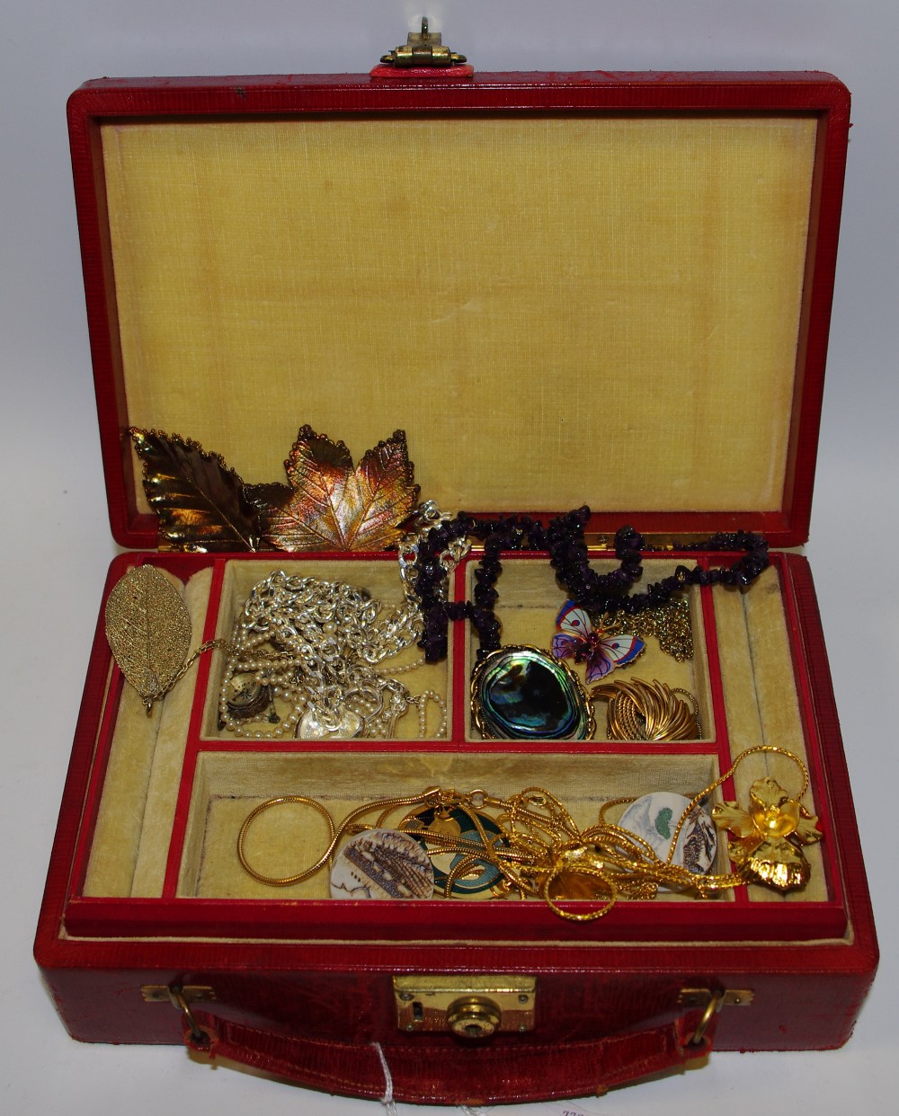 A red Moroccan leather travelling jewellery case containing gilt mounted Abalone brooch;