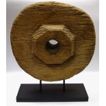 Architectural Salvage - an unusual wooden cartwheel, mounted on a black rectangular stand,