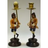 A pair of novelty cold painted metal candlesticks of a monkey in 18th century dress,