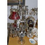 A reproduction candle lamp; a wrought iron three branch candelabrum;