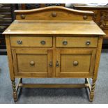 An early/mid 20th century oak sideboard, arched gallery, two short drawers over two door cupboard,