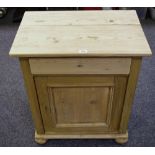 A pine bedside cabinet short drawer over panel door cupboard