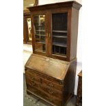A George III oak bureau bookcase, outswept cornice over two glazed doors,