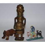 A lead figure - man spanking boy with dog; African Art - a Benin brass figure of a lady with a bowl;