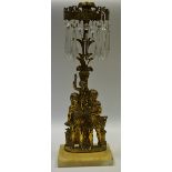 An unusual brass figural candle lustre, cast with a Romanesque family,