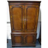 A reproduction mahogany cocktail cabinet, stepped cornice, two doors enclosing mirrored back panel,