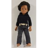 A vintage 1960/70s Sasha doll, brown hair and body, blue denim jeans with patterned braces,