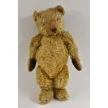 An early 20th century Teddy bear, possibly Chad Valley, long brown vertical stitched nose and mouth,