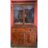 A Post-Regency mahogany secretaire bookcase, shaped cresting outlined with ebony stringing,