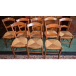 A harlequin set of eight 19th century French Provincial cherry wood dining chairs, arched bar backs,