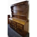 A country oak dresser, ogee cornice, shaped uprights to top,