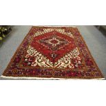 A large hand woven Middle eastern rug, geometric designs in hues of green,