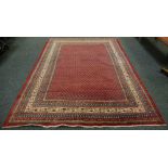 A hand woven Araak carpet the panels decorated in deep tones of Burgundy,