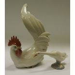A Lladro porcelain model of a cockerel neutral tones, seated with tail raised, 9" (22.