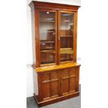 A mahogany bookcase, ogee cornice over two glazed doors enclosing adjustable shelving to top,