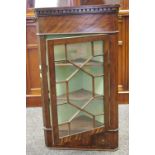 A late 19th/early 20th century fiddle back mahogany splay front corner cabinet,