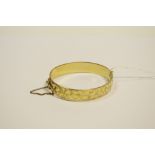 A 9ct gold with metal core hinged bangle