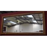 A large light oak framed wall mirror, bevelled plate,