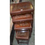 An oak nest of four tables, the tops carved in the Chinese taste,