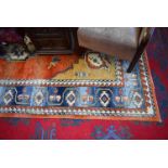 A Middle Eastern style woollen carpet, in tones of blue, red and cream,