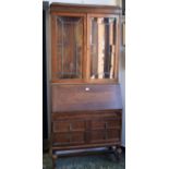 A mid 20th century oak bureau bookcase, moulded cornice above a pair of glazed and leaded doors,