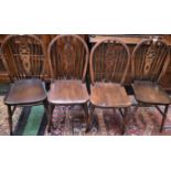 A set of four wheel back dining chairs
