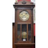 A mid 20th century oak cased wall clock, twin winding holes,